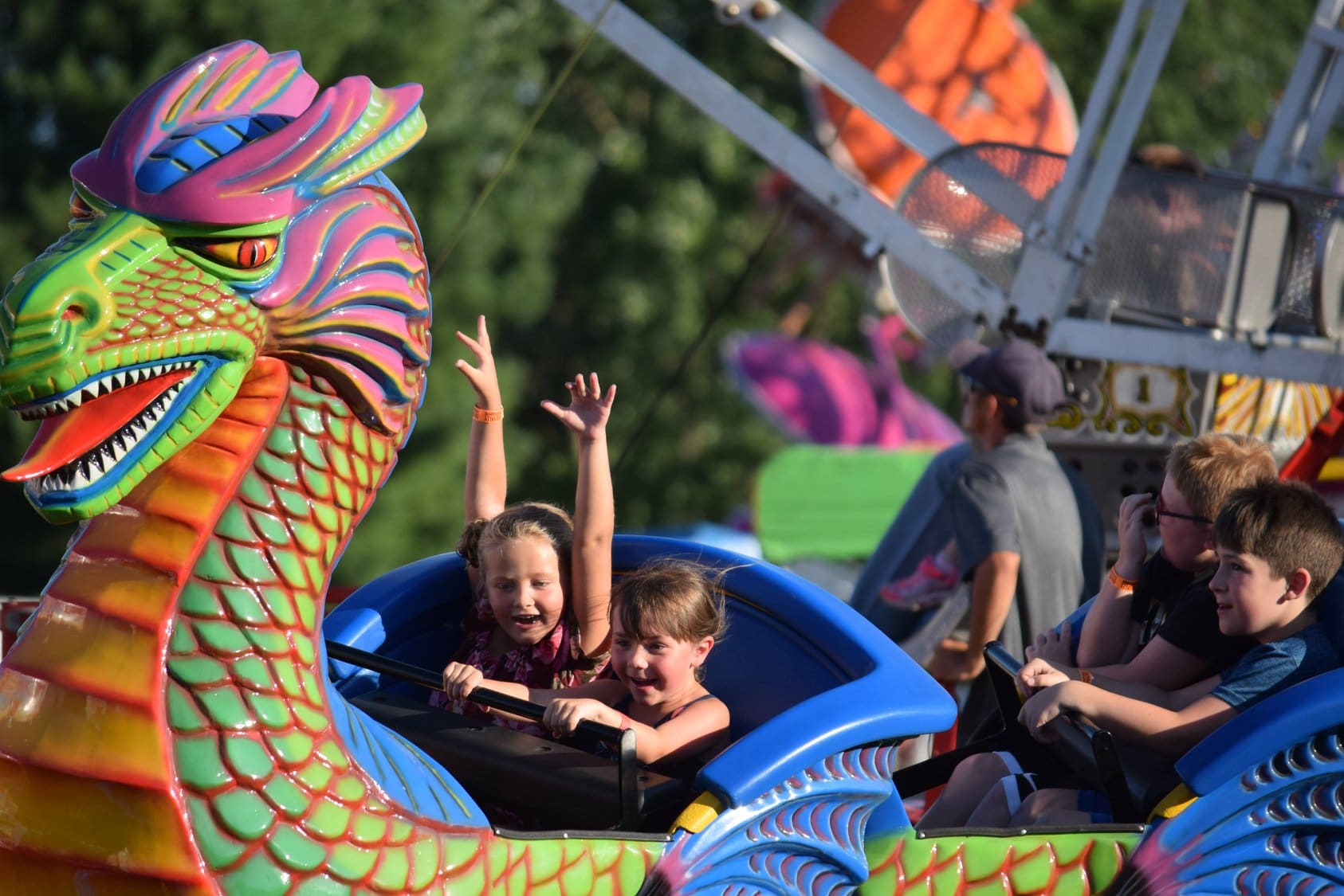 Aerial view of the Adams County Fair Midway with colorful carnival rides and game booths.